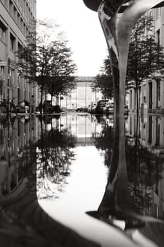 Vertical shot of the reflection of a sculpture in the water near Potsdamer Platz