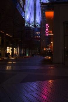 Vertical shot of the neon sign of a bar near the Sony Center