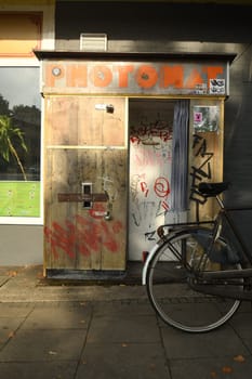 Vertical shot of a vintage style wooden Photo Booth with a bike parked in front of it