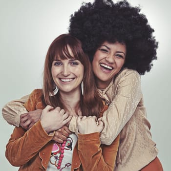 Soul sisters. Cropped studio portrait of two girl friends in retro style outfits