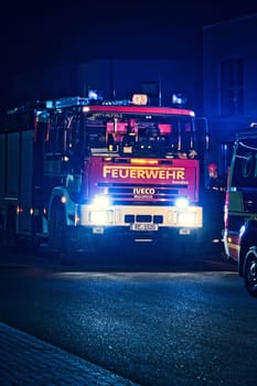 Vertical shot of a red German fire truck at night operation