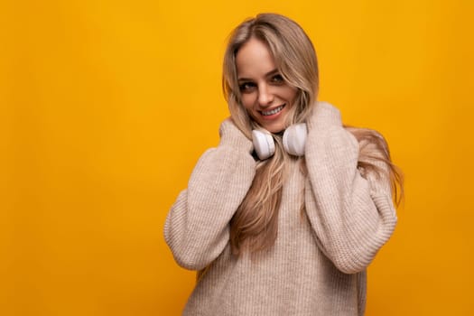 girl with a grimace in headphones on a yellow background.