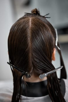 young girl gets fashionable haircut in modern hairdressing salon