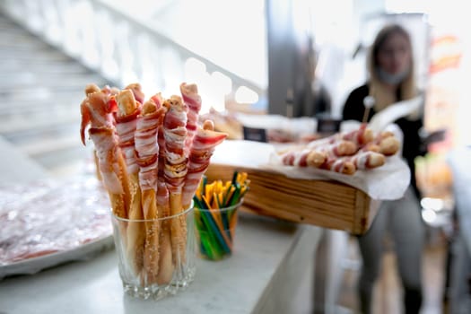 Meat appetizer for a buffet table against the background of a blurred hall.