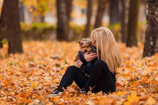 girl with her little dog in autumn park