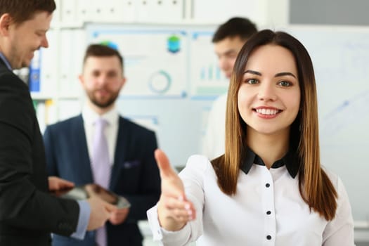 Businesswoman holds out hands for handshake and business team. Handshake gesture and business meeting in office