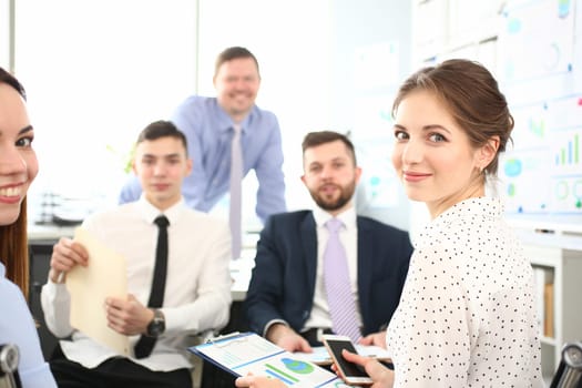 Mentor manager speaks at executive team meeting in boardroom. Mentor trains executive team at board briefing and business people discuss strategy in office