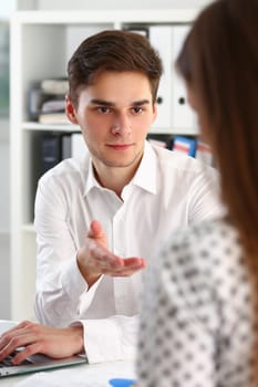 Young manager consultant explains business project to female colleague. Communication business people workplace concept