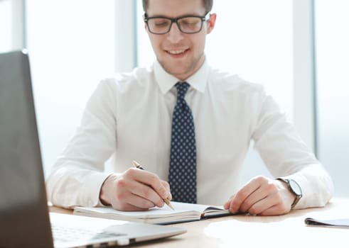 Closeup of business man writing form on clipboard.