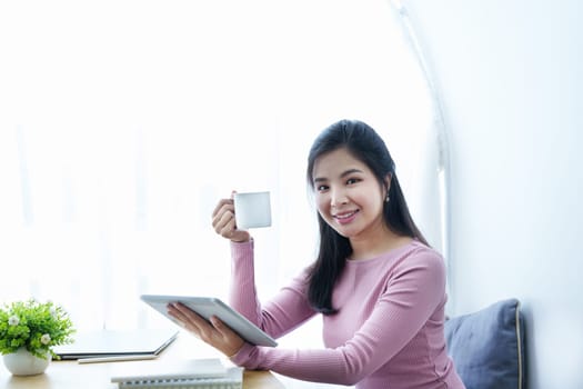 Portrait of a beautiful Asian teenage girl using a tablet computer.