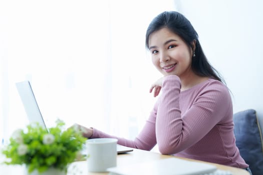Portrait of a beautiful Asian teenage girl using a computer.