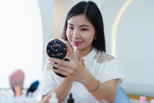 online trading business, a beautiful young woman working independently at home reviewing cosmetic products through the camera to customers to increase their interest in making a purchase decision.