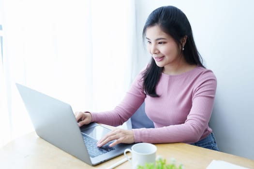 Portrait of a beautiful Asian teenage girl using a computer.