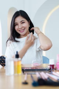 online trading business, a beautiful young woman working independently at home reviewing cosmetic products through the camera to customers to increase their interest in making a purchase decision.