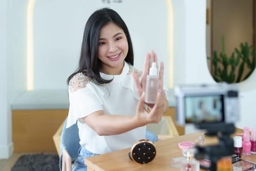 online trading business, a beautiful young woman working independently at home reviewing cosmetic products through the camera to customers to increase their interest in making a purchase decision.