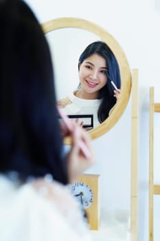 online trading business, a beautiful young woman working independently at home reviewing cosmetic products through the camera to customers to increase their interest in making a purchase decision.