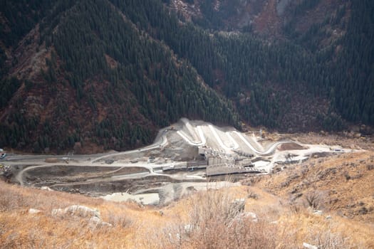 Top view on erection of a mudflow protection dam in the Big Almaty Gorge in the mountains of Almaty. Almaty, Kazakhstan - September 28, 2022