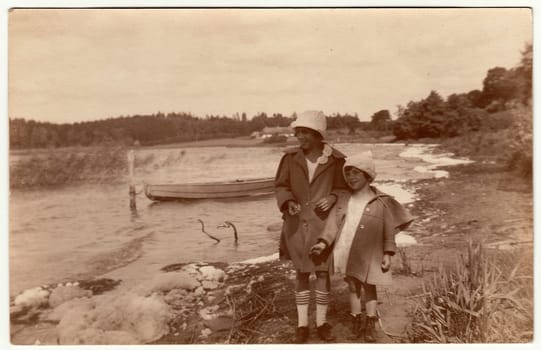 GERMANY - 1926: Vintage photo shows two girls go along the riverside. Black & white antique photography.