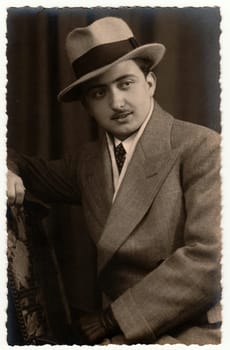 GERMANY - CIRCA 1930s: Vintage photo shows man wears salt and pepper suit and wide - brimmed hat. Antique black and white studio photography.