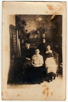 TISNOV, THE CZECHOSLOVAK REPUBLIC - CIRCA 1920s: Vintage photo shows four women in the living room. Photography contains slight blurriness, sepia effect.