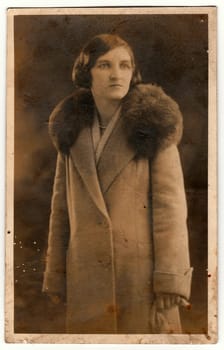 THE CZECHOSLOVAK REPUBLIC - CIRCA 1940s: Vintage photo shows an elegant woman wears light coat with fur collar. Black white antique photography.