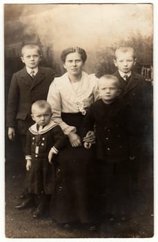 GERMANY - CIRCA 1920s: Vintage photo shows mother and her four sons. One of them wears sailor costum. Black white antique photography.