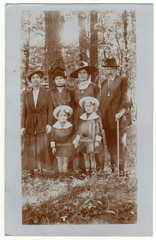 DRESDEN, GERMANY - MAY 26, 1918: Vintage photo shows family and close relatives pose in the nature in the forrest .