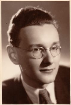 PRAHA (PRAGUE), THE CZECHOSLOVAK SOCIALIST REPUBLIC - 1951: The vintage photo shows young man wears glasses. The photography was taken for A level (GCSE exam) occasion.