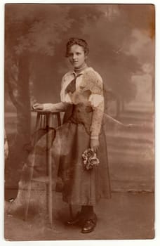 WIEN, AUSTRIA - 1929: Vintage photo shows a young woman holds roses. Studio photography with sepia effect.