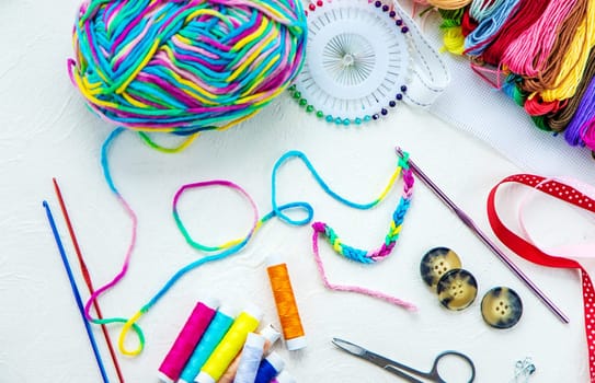 Threads and accessories for sewing and knitting. Selective focus. white.