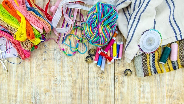 Threads and accessories for sewing and knitting. Selective focus. white.