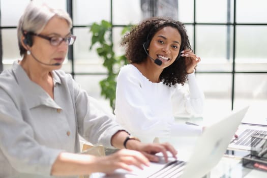 Young friendly operator woman agent with headsets working in a call centre