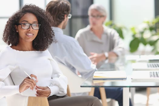 young attractive african american woman in the office sitting at the table