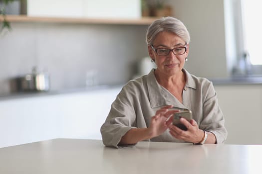 mature woman calls on the phone in the office sitting at the table
