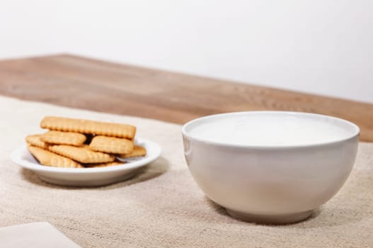 Milk in bowl with cookies on table , leisure time