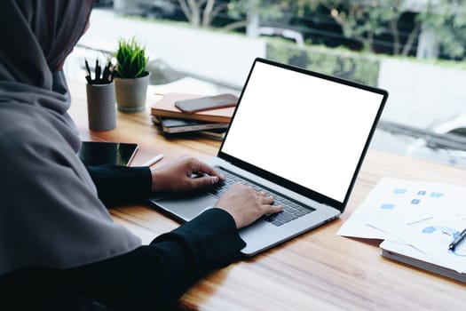 A beautiful Muslim woman uses a white computer screen ready to put text and illustrations on empty spaces.