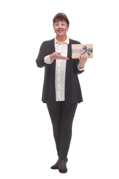 Full body senior woman happy and smiling, holding a gift looking at camera