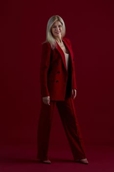 Portrait of a blonde woman in red dress on a red background
