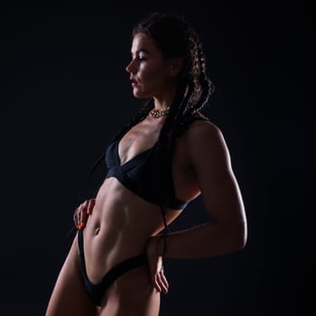 Close-up shot of young woman waist with muscular abdominal muscles. Abs of a fit female athlete.