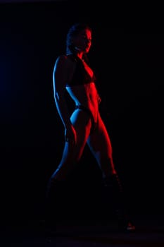 Young woman in underwear is in a studio with neon lights.