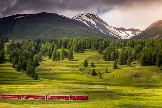 Red train with Alpine landscape of St Moritz, Engadine, Muottas Muragl, Switzerland