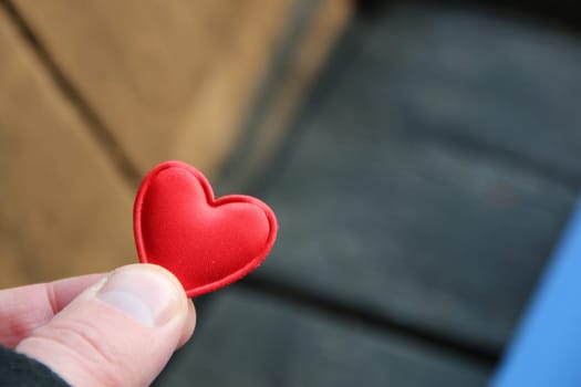 Human hand holding red toy heart. Valentine's Day concept.