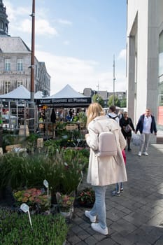People walk among Variety of flower choices at the market in the central square in Maastricht, Netherlands, August 27, 2021. High quality photo