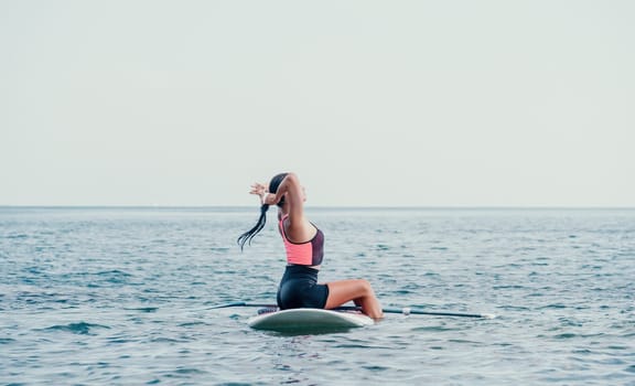 Sea woman sup. Silhouette of happy young woman in pink bikini, surfing on SUP board, confident paddling through water surface. Idyllic sunset. Active lifestyle at sea or river. Slow motion