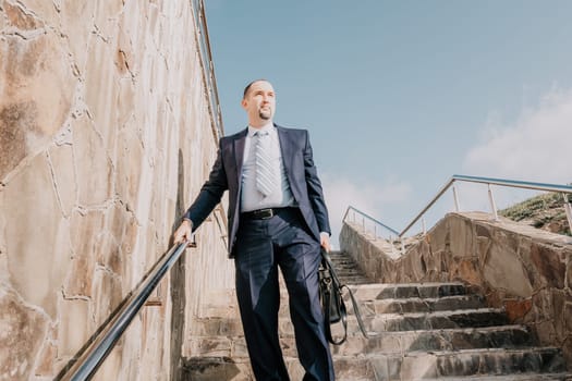 Business executive with briefcase going down the stairs.