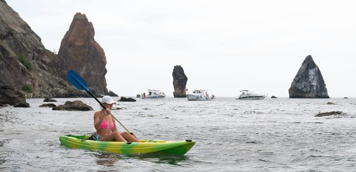 Kayaking. Travel adventure kayak on the tropical sea on a sunny day. Woman rowing a canoe.