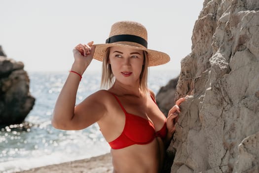 Woman travel sea. Young Happy woman in a long red dress posing on a beach near the sea on background of volcanic rocks, like in Iceland, sharing travel adventure journey