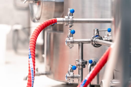 stainless steel boilers and vessels with pipes for brewing beer in a brewery.