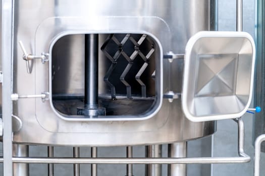 stainless steel boilers and vessels with pipes for brewing beer in a brewery.