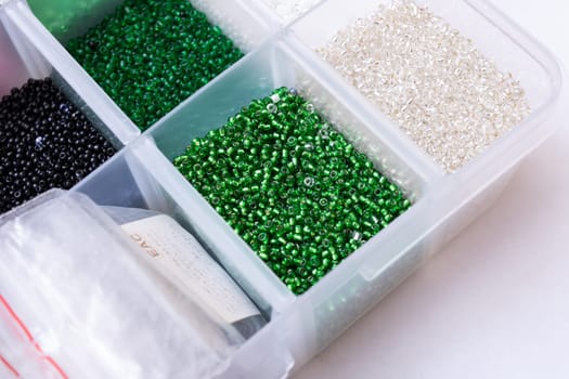 Colorful beads in containers close up, handicrafts, macrophoto